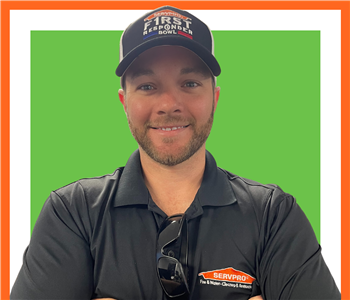 Kevin Biggers, SERVPRO employee male, in front of white background and green servpro sign